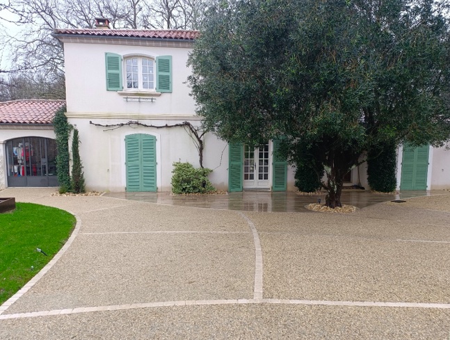 Cour de maison : terrasse imitation bois, béton désactivé et allées stabilisées